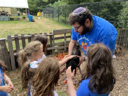 staff member showing chicken to campers.